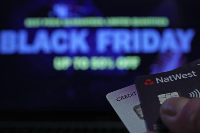 A person holding bank cards in front of a screen during ‘Black Friday’, in London.