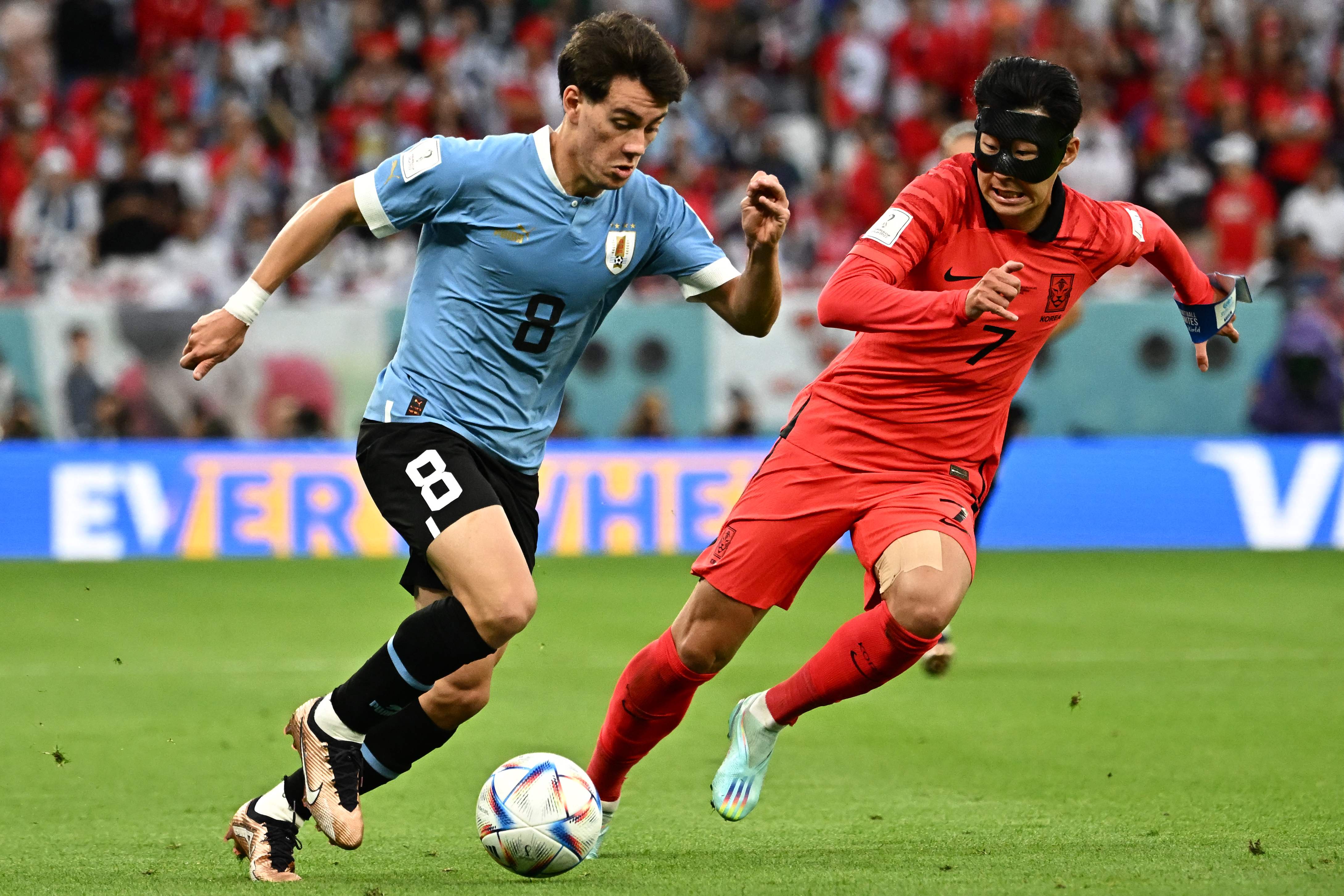 <p>Facundo Pellistri runs with the ball past South Korean midfielder Son Heung-min</p>