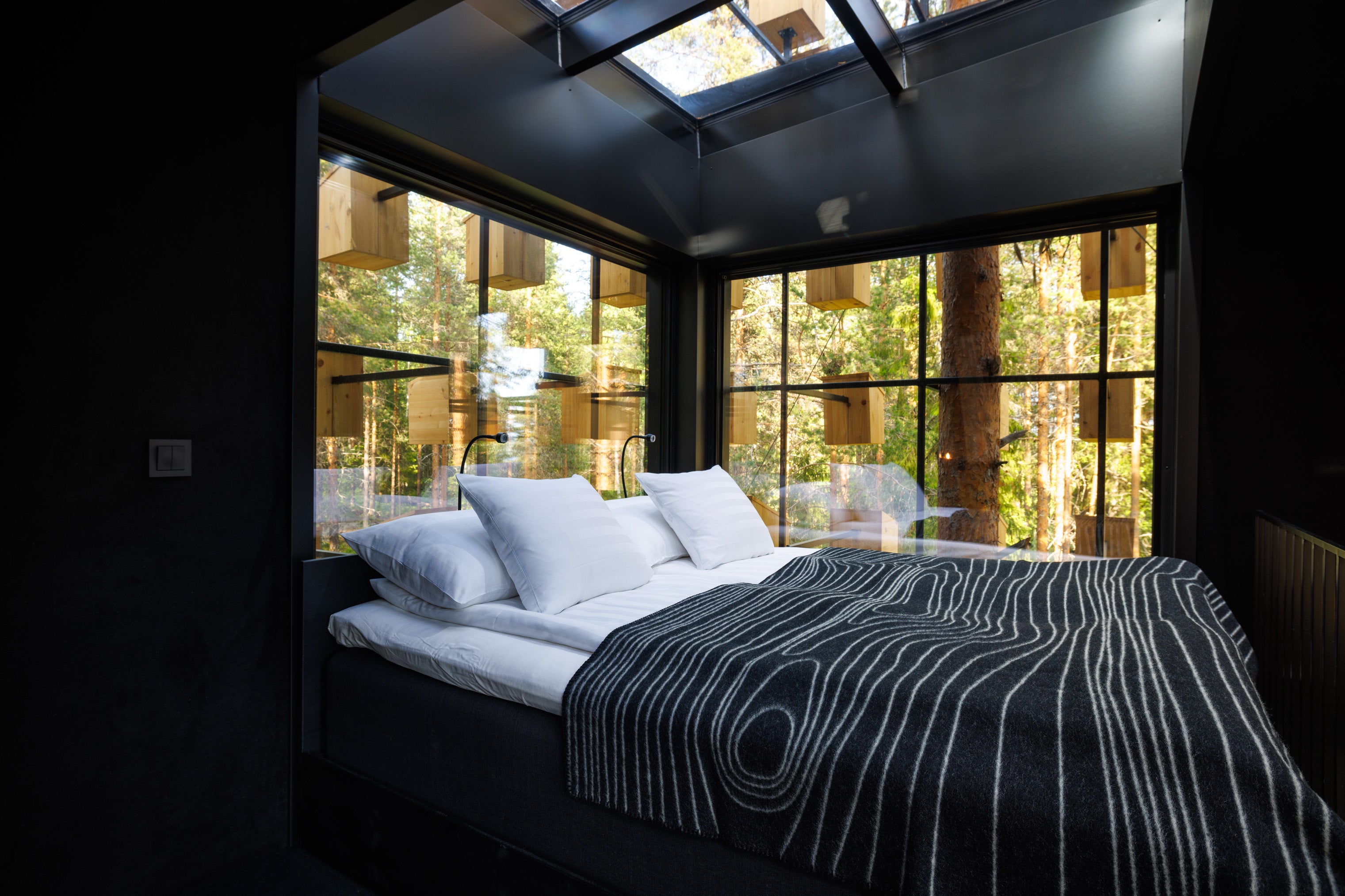 The bed is set on a mezzanine level and features a glass roof