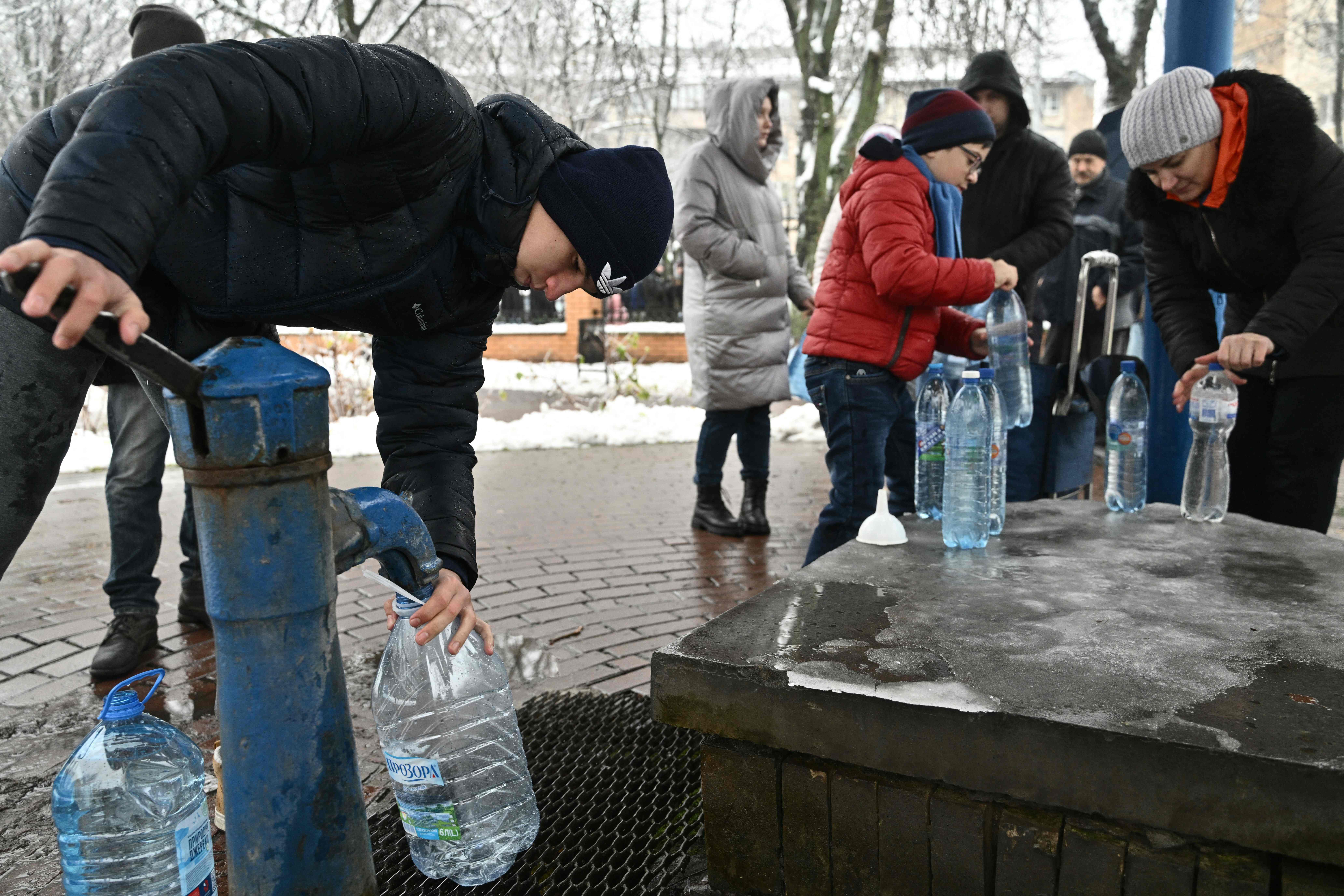 Kyiv residents fill plastic bottles at a water pump in a park in Kyiv