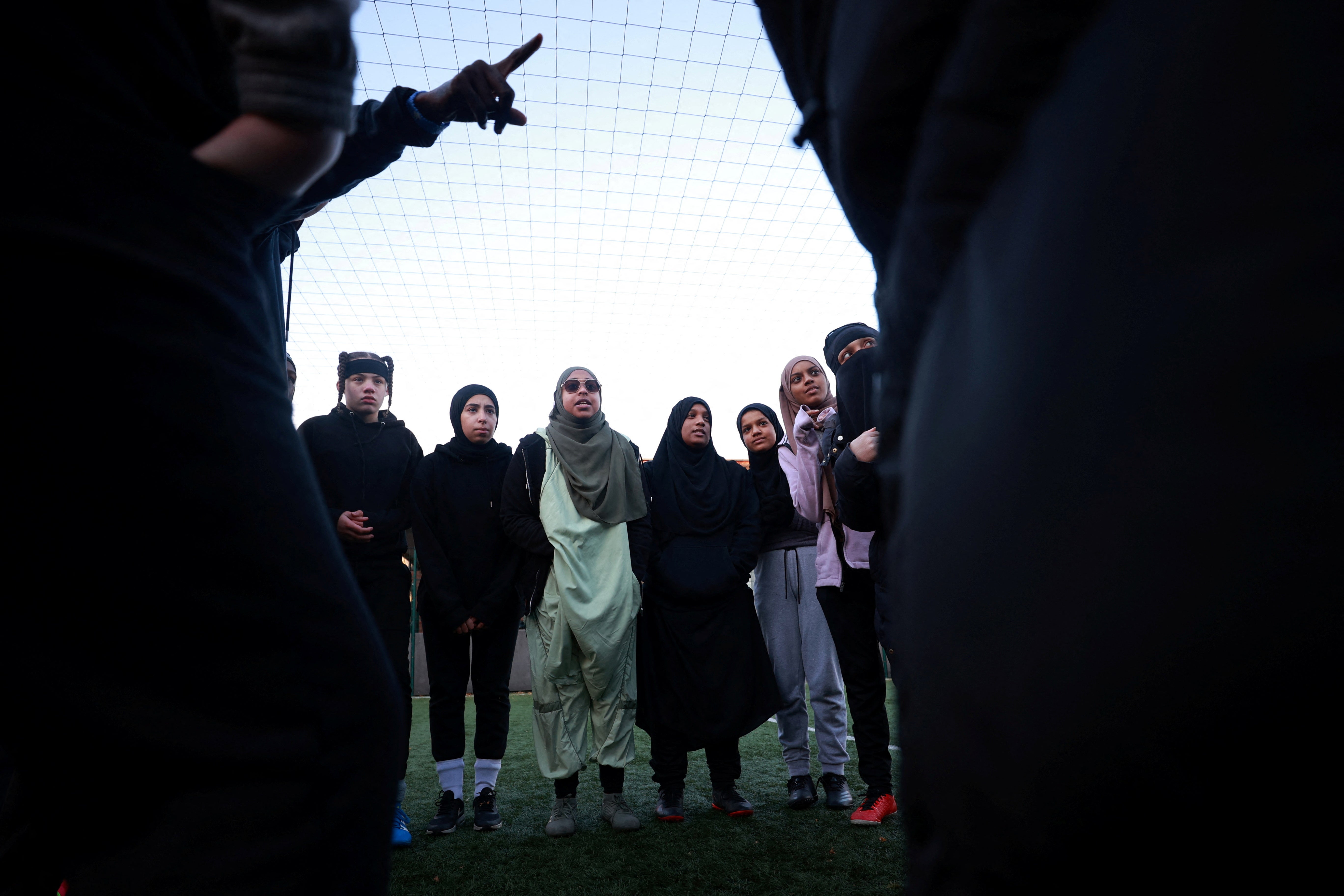 Team members huddle during a Sisterhood training session