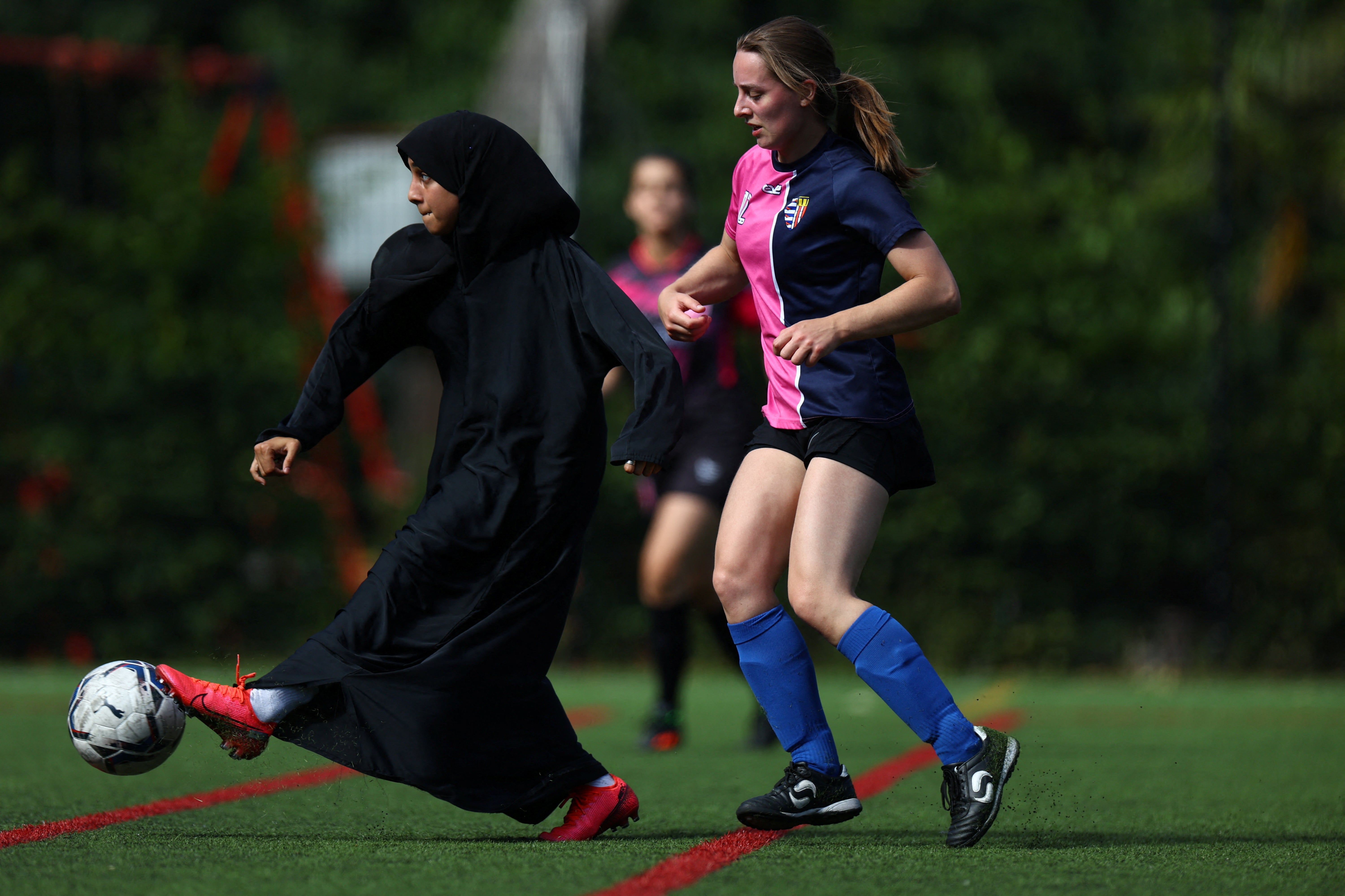 Sisterhood player Raya Ahmed kicks the ball during a tournament match against PCWAFC at Archbishop's Park football pitch