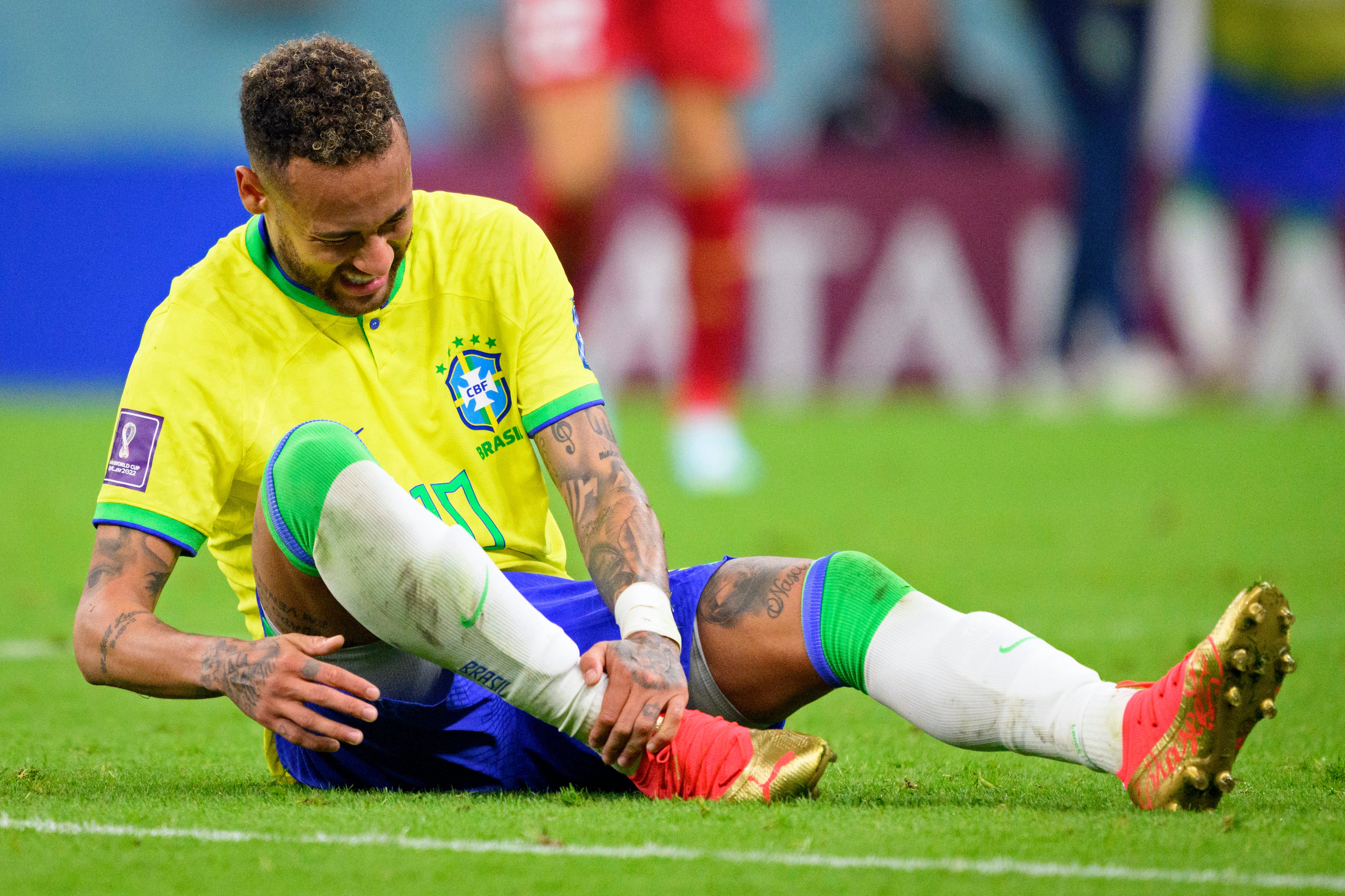 Neymar holds his ankle during the match with Serbia