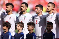 Iran players sing national anthem while fans jeer before Wales World Cup match