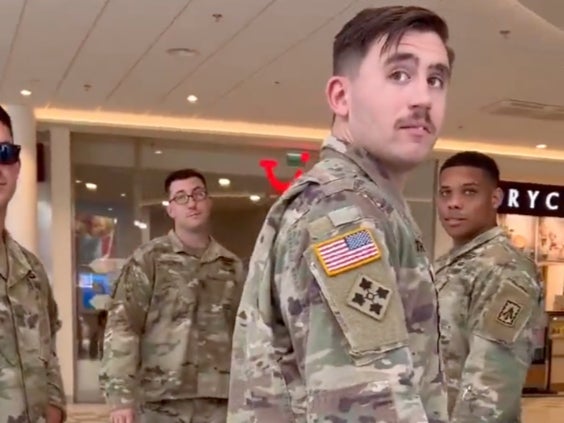 A group of US soldiers looks back as a man filming them hurls slurs and insults at them