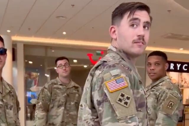 <p>A group of US soldiers looks back as a man filming them hurls slurs and insults at them</p>