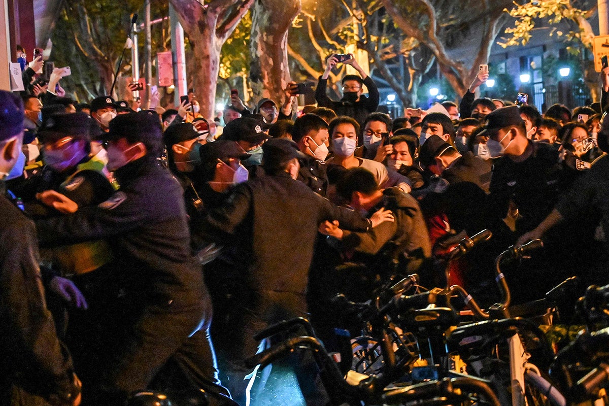 Police and guards arrest a man during some clashes in Shanghai