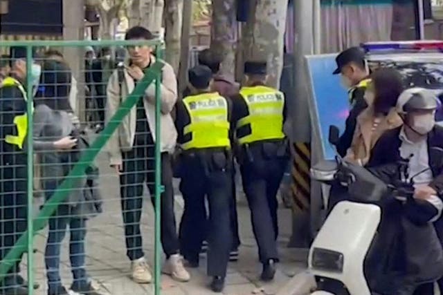 <p>This frame grab from AFPTV video footage shows police detaining a person on Wulumuqi street, named for Urumqi in Mandarin on Monday</p>