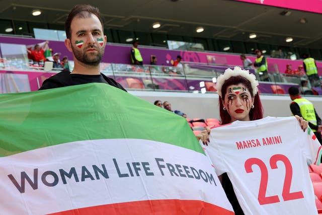 <p>Iranian supporter holds a football jersey reading the name of Mahsa Amini, the 22-year-old Iranian Kurdish woman who died at the hospital after been arrested by the morality police for violating Iran’s strict dress code</p>