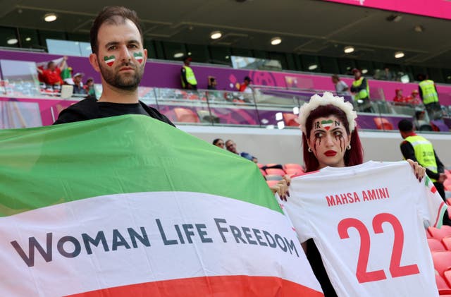 <p>Iranian supporter holds a football jersey reading the name of Mahsa Amini, the 22-year-old Iranian Kurdish woman who died at the hospital after been arrested by the morality police for violating Iran’s strict dress code</p>