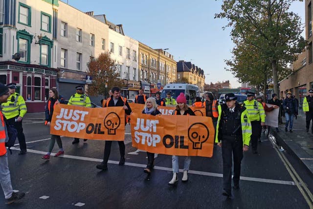 <p>Just Stop Oil carried banners along the street in west London</p>