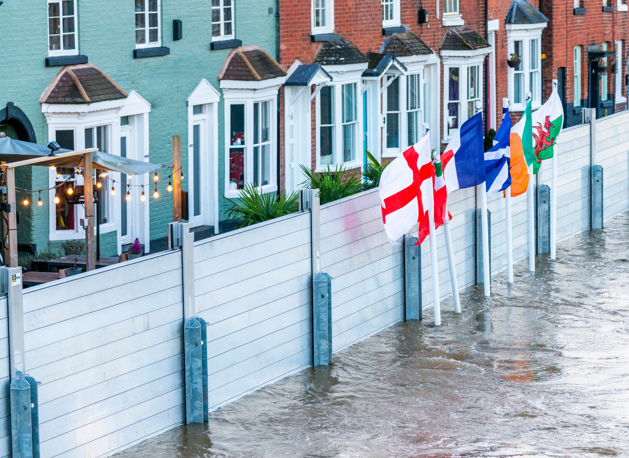 <p>Emergency flood barriers protect homes in Bewdley Bridge, Worcestershire, earlier this year following torrential rain</p>