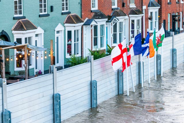 <p>Emergency flood barriers protect homes in Bewdley Bridge, Worcestershire, earlier this year following torrential rain</p>