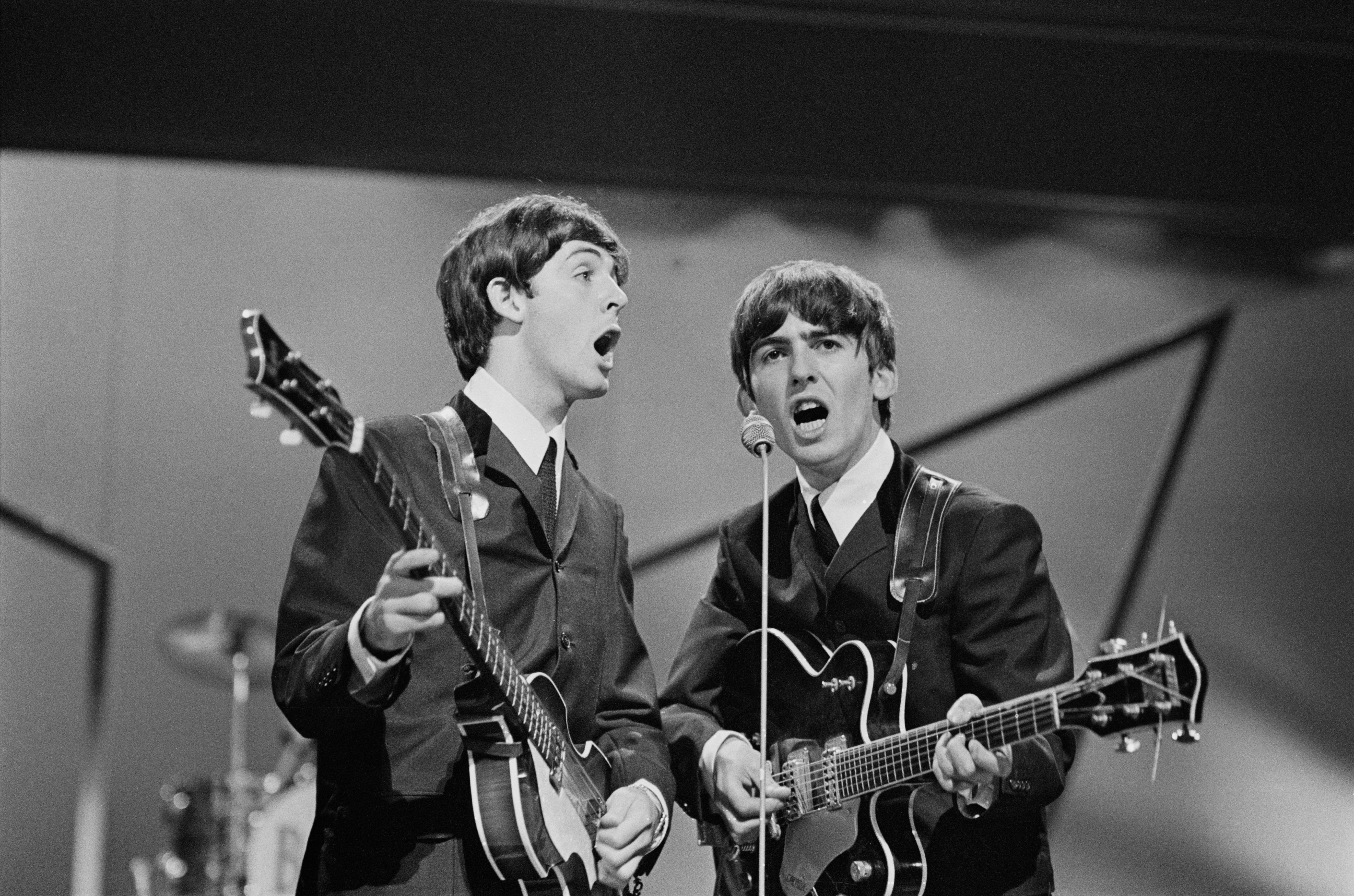 Paul McCartney and George Harrison on stage at the London Palladium on 13 October 1963