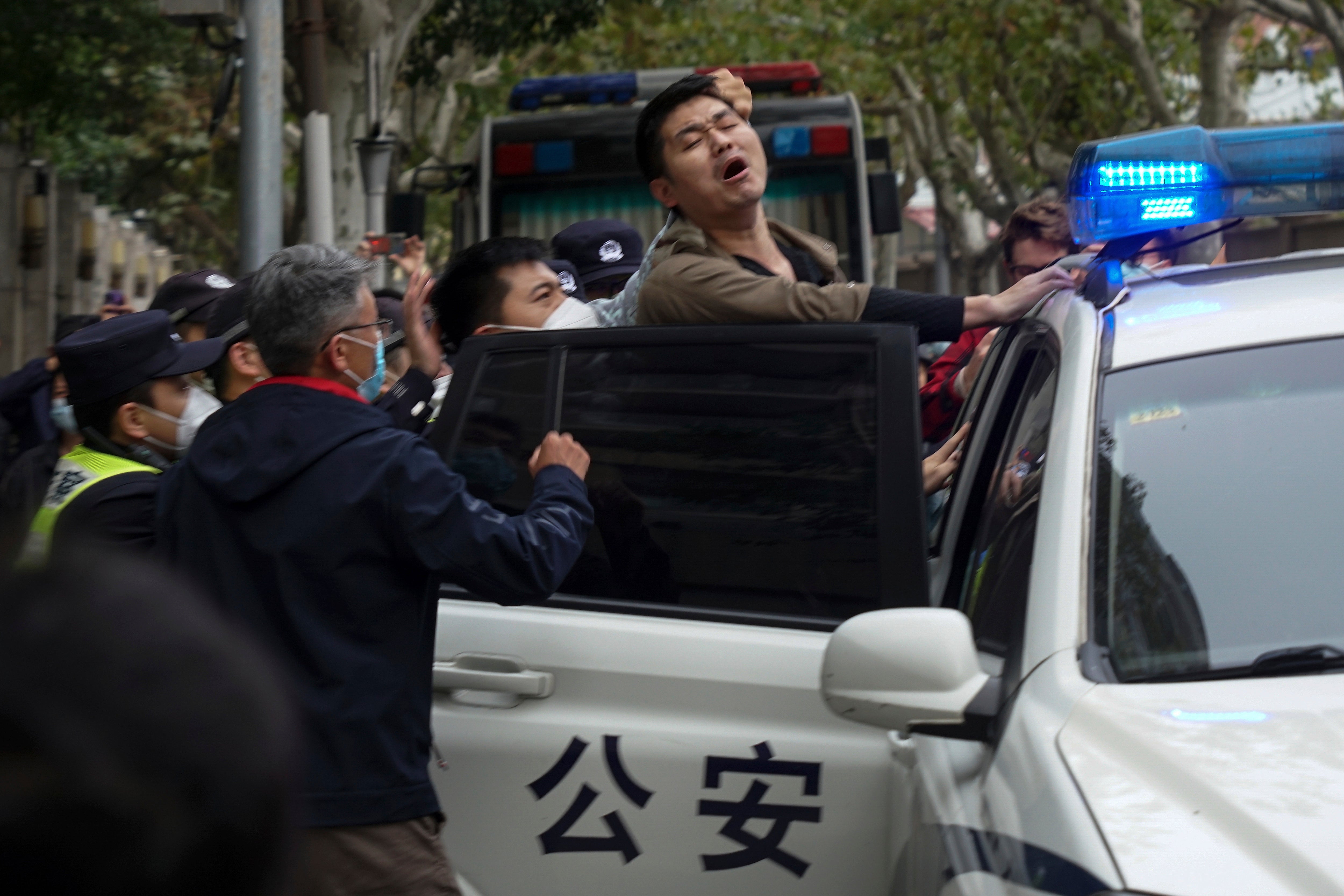 A protester is arrested during a street protest in Shanghai on Sunday