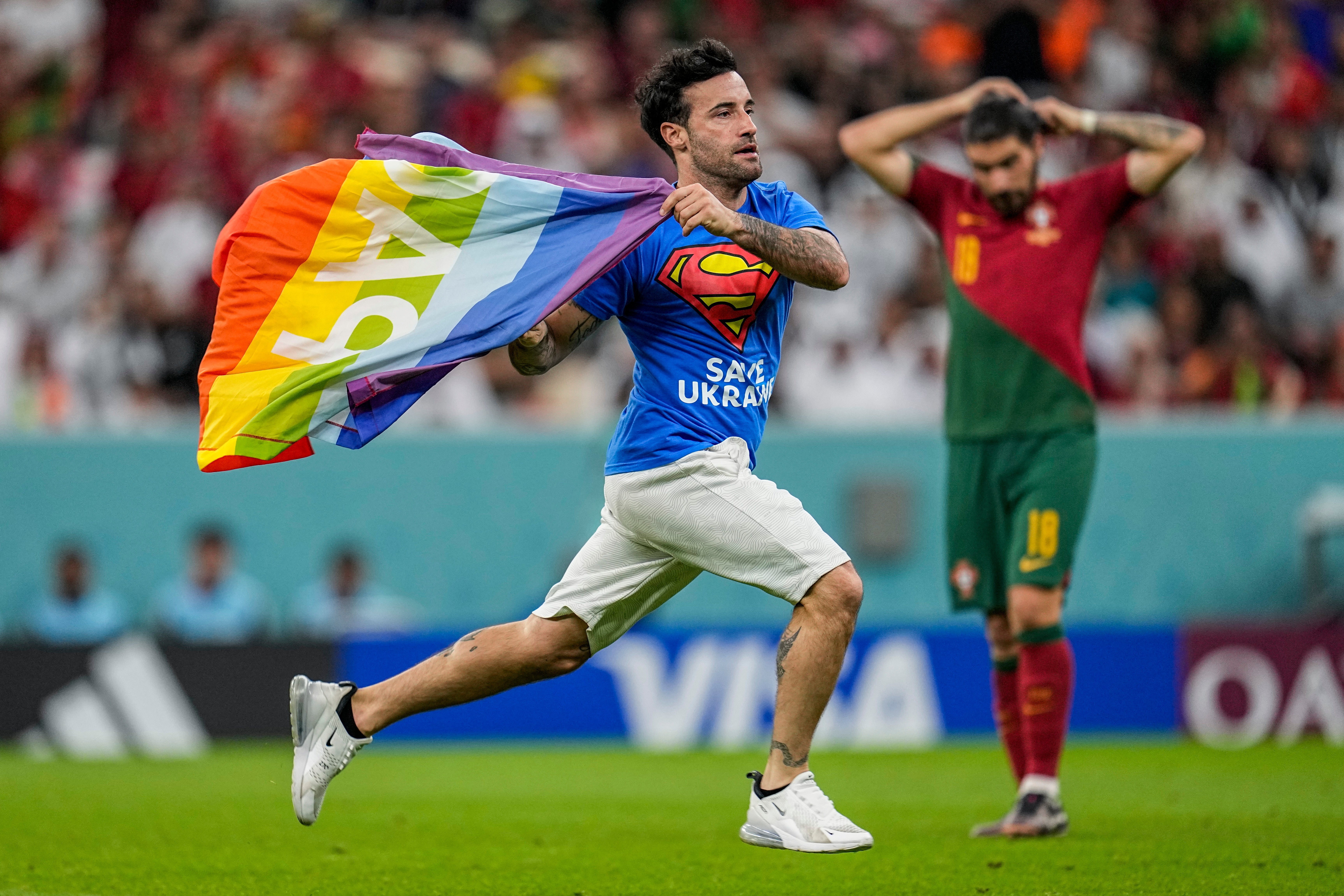 A fan interrupts the match at the Lusail Stadium with a pride flag