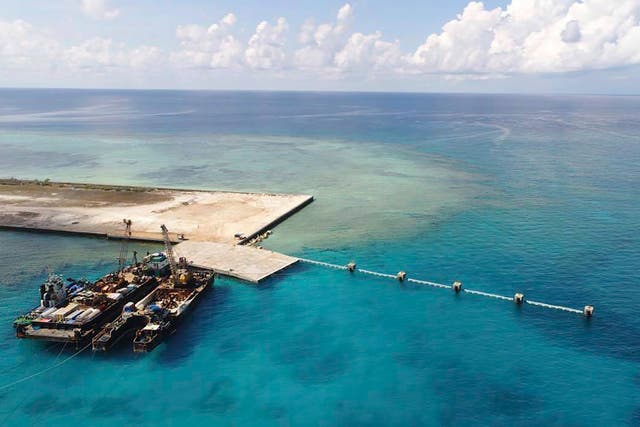<p>In this photo from 9 June 2020, provided by the Department of National Defense, ships carrying construction materials are docked at the newly built beach ramp at the Philippine-claimed island of Thitu, in the disputed South China Sea</p>