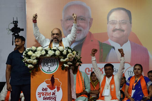 <p>Indian home minister Amit Shah (centre) gestures during a Bharatiya Janata Party (BJP) rally ahead of Gujarat’s assembly election at Naroda in Ahmedabad on 25 November 2022</p>