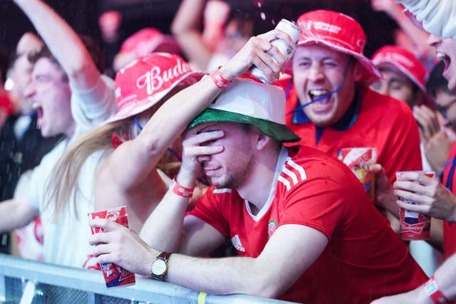 England fans celebrate next to a dejected Wales fan at the Budweiser Fan Festival London at Outernet, during a screening of the FIFA World Cup Group B match between Wales and England. Picture date: Tuesday November 29, 2022.