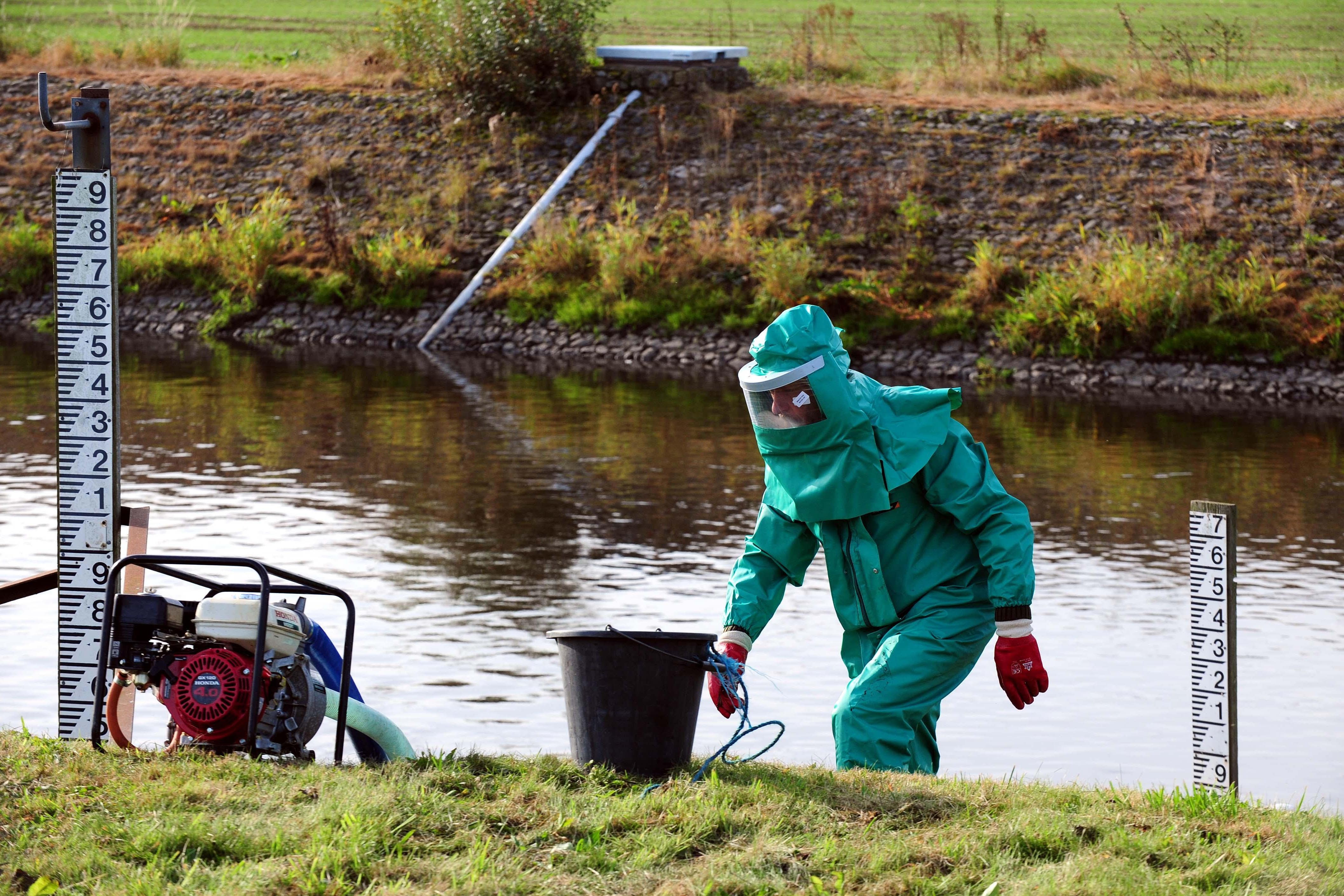 An Environment Agency worker treats the River Trent at Yoxall, Staffordshire (PA)