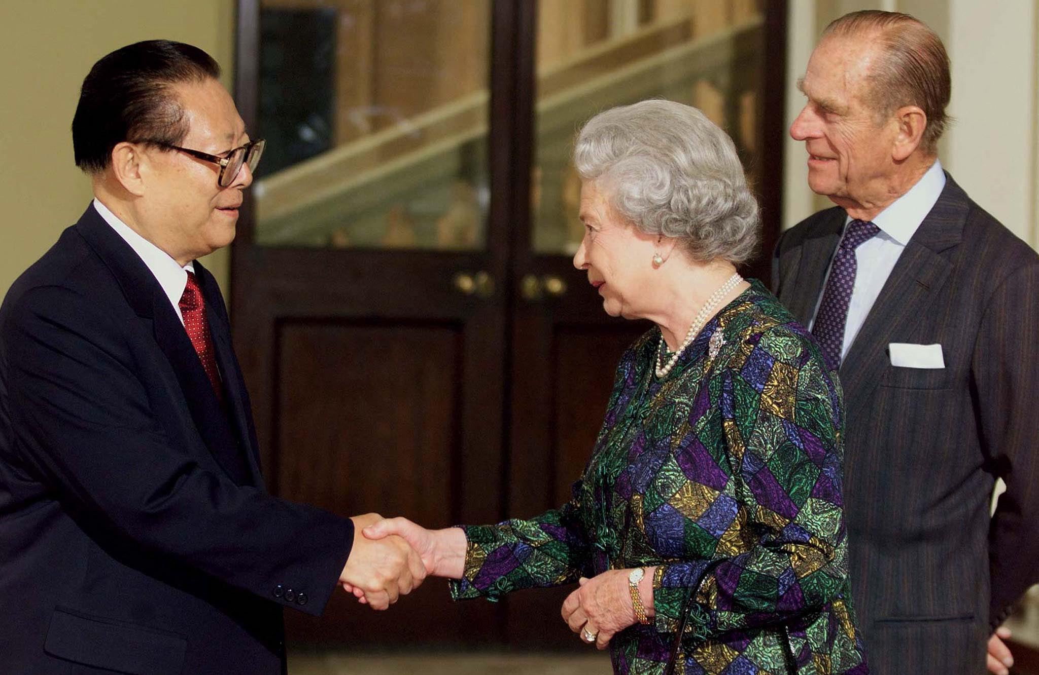 Jiang Zemin and the Queen Elizabeth II shake hands as Prince Philip looks on at the steps of Buckingham Palace 22 October 1999