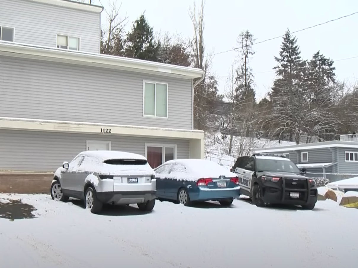 Two cars and a police vehicle sit outside the home where four University of Idaho students were murdered on 13 November. Police seized five cars from near the scene on 19 November