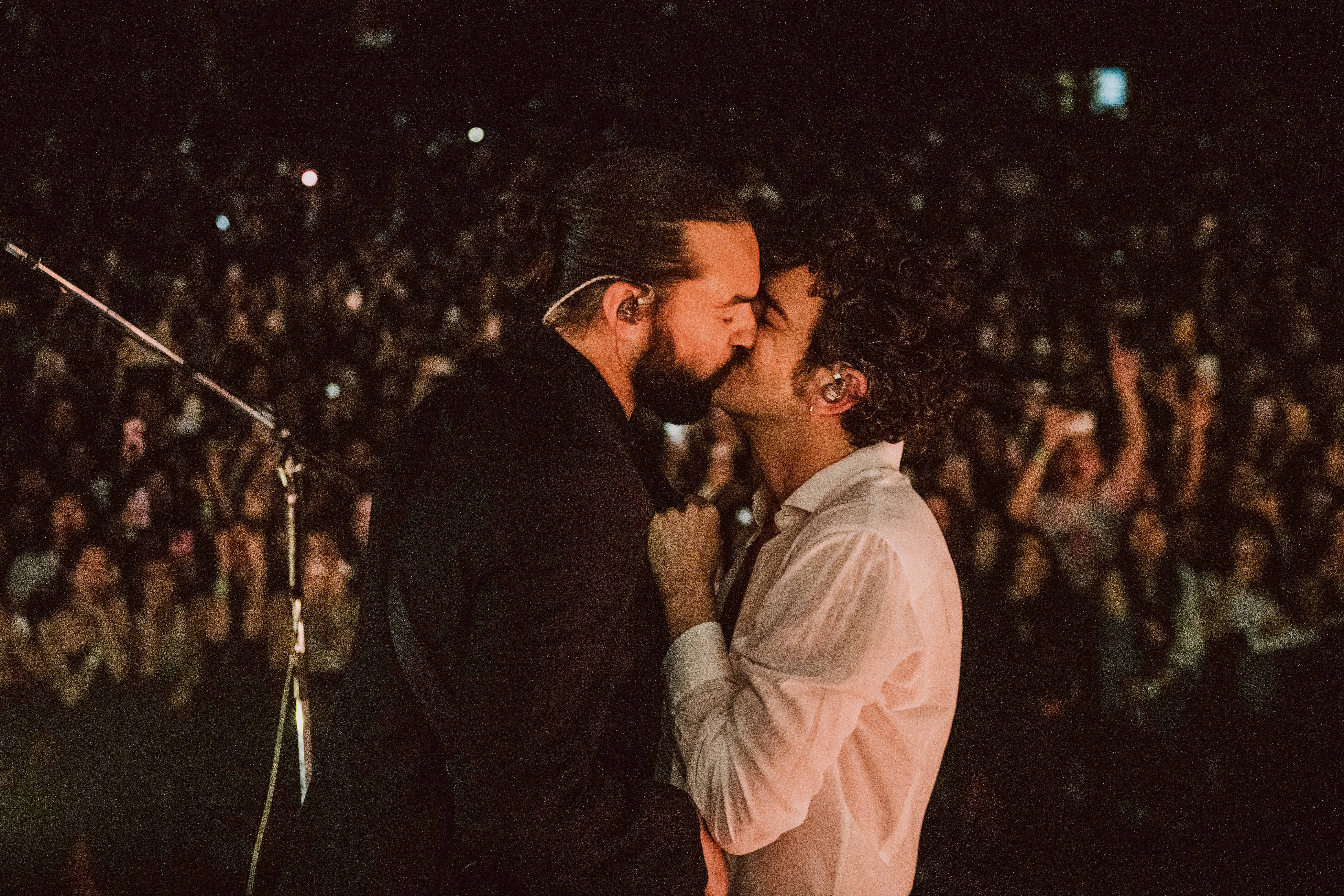 Matty Healy (right) kisses Ross MacDonald on stage at the Kia Forum, Los Angeles
