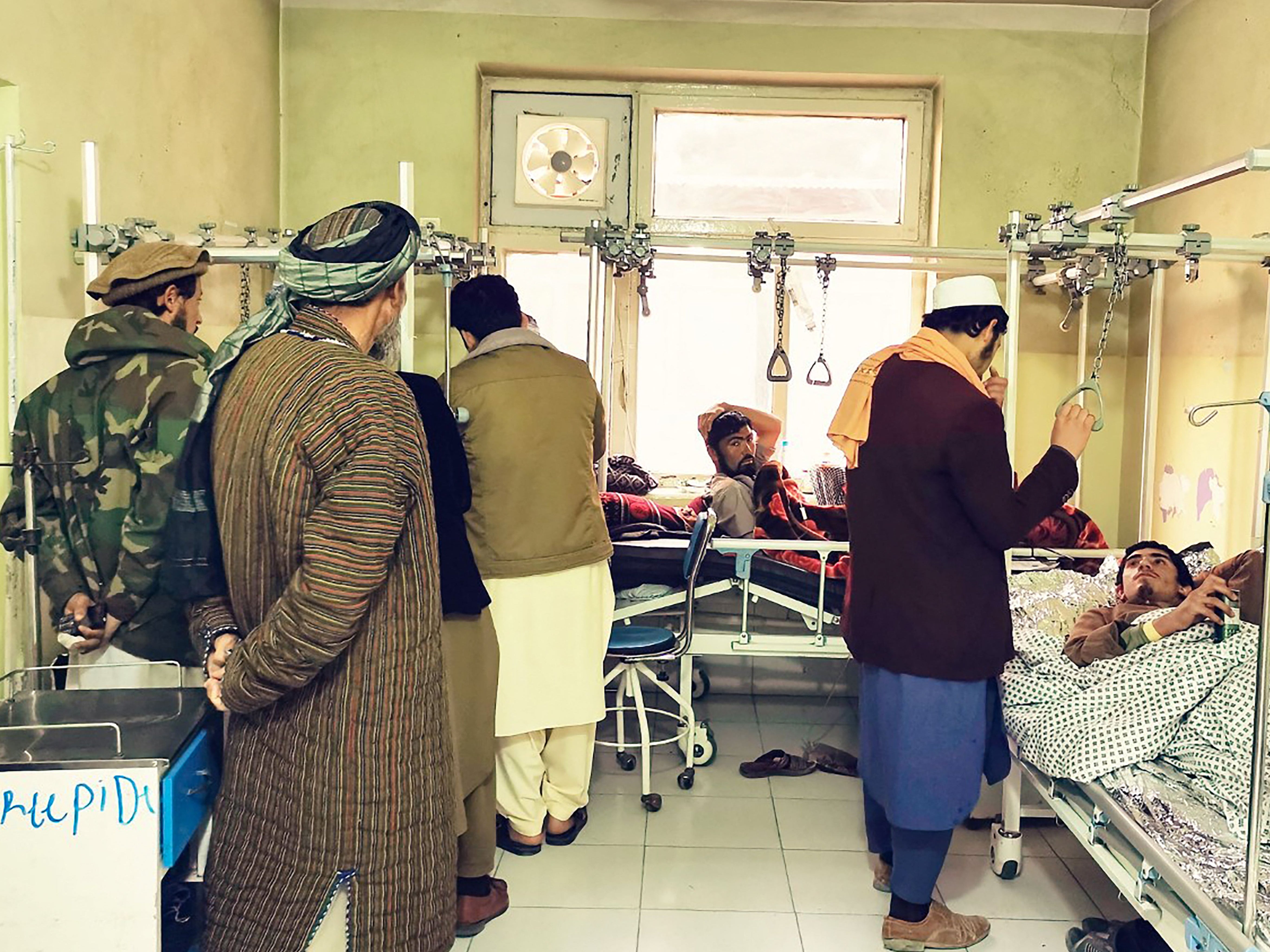 Wounded Afghan men receive treatment at a hospital following a blast at a madrassa in Aybak city of Samangan province on 30 November 2022