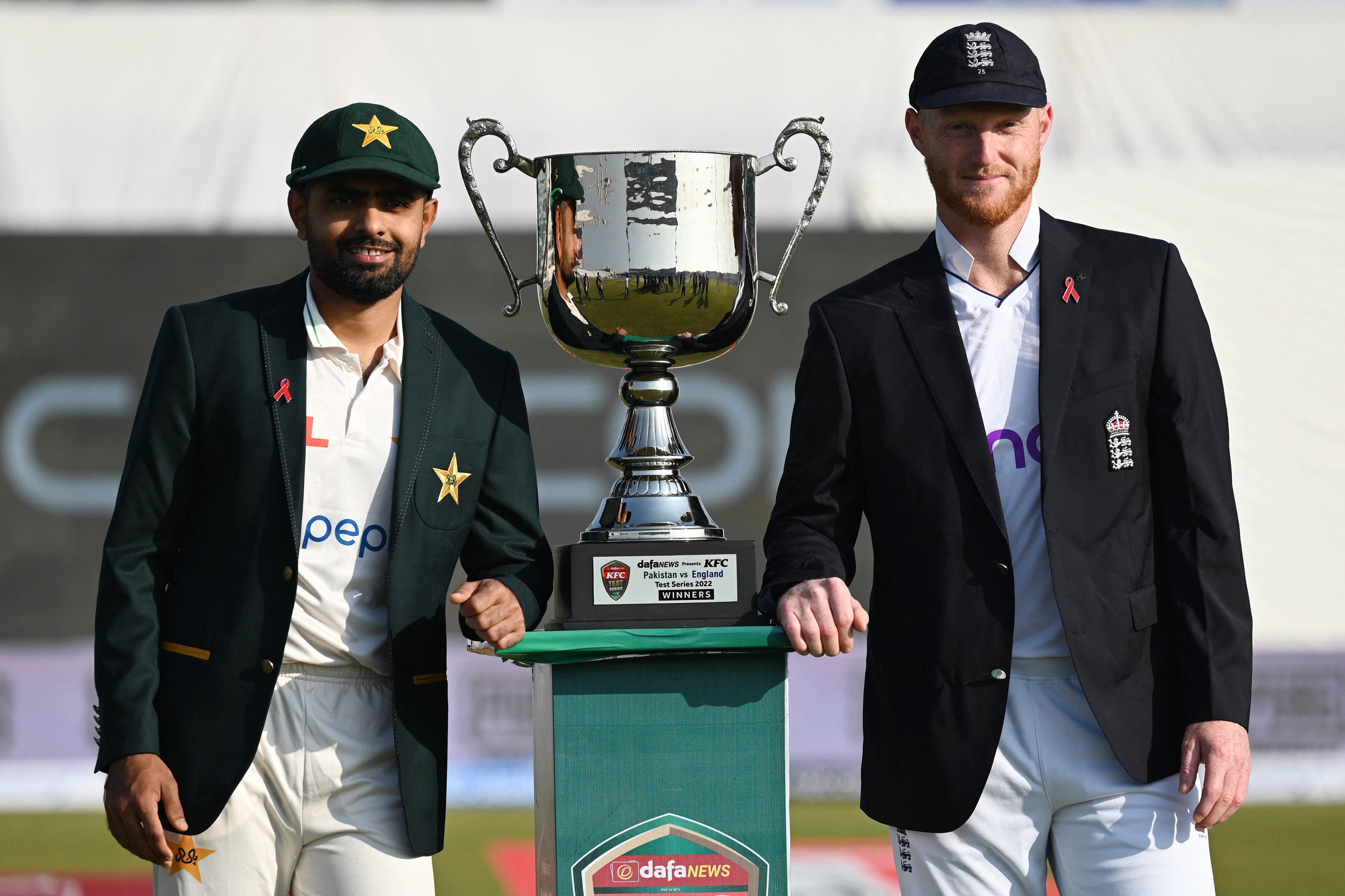 Pakistan's captain Babar Azam (L) and his England's counterpart Ben Stokes pose with the Test series trophy