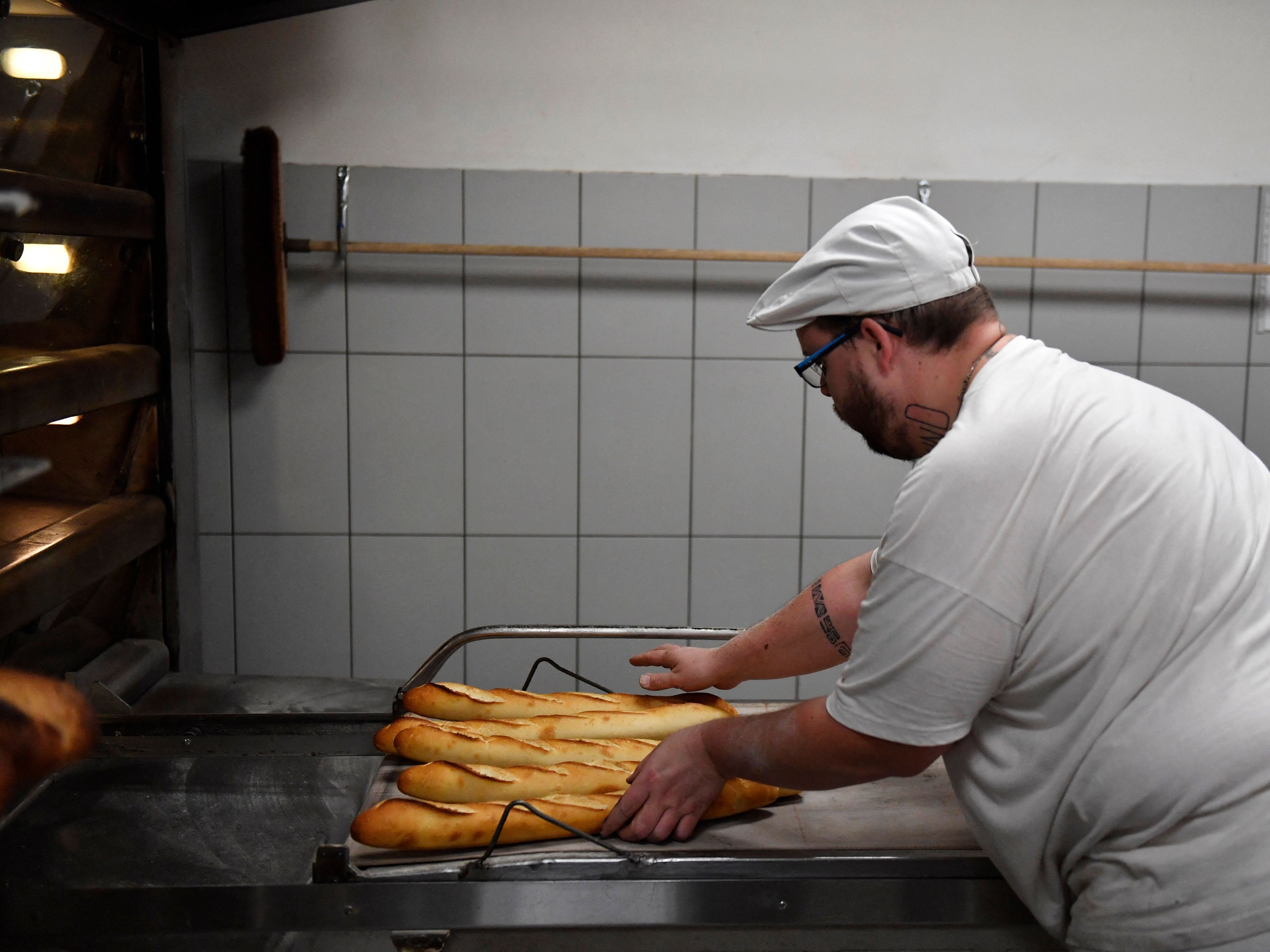 A baker prepares baguettes in a bakery in Brou near Chartres on 1 December 2022