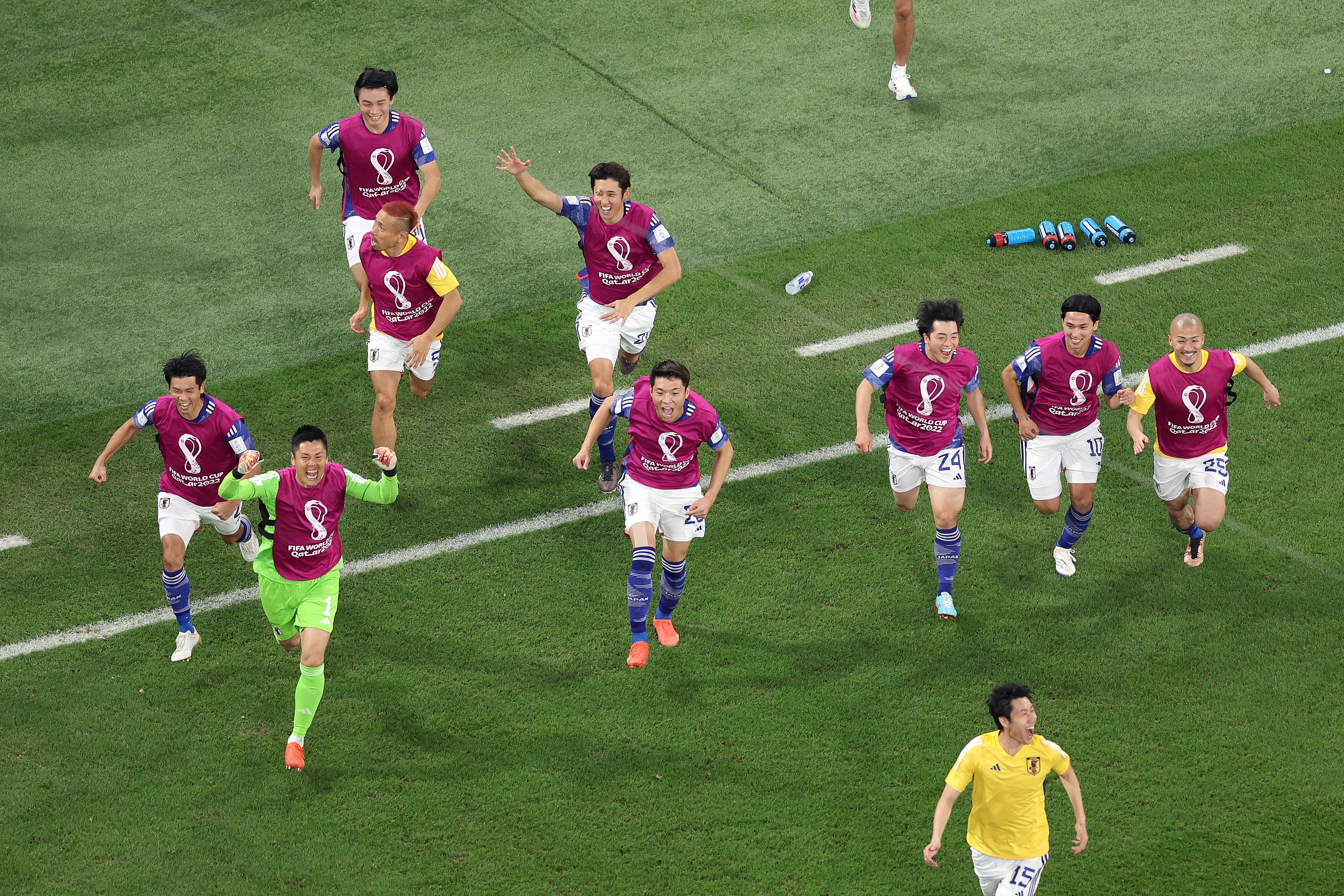 Japan’s players celebrate after the team’s qualification for the knockout stages