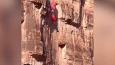 Base jumper dangles off cliff after slamming into rocks during parachute malfunction