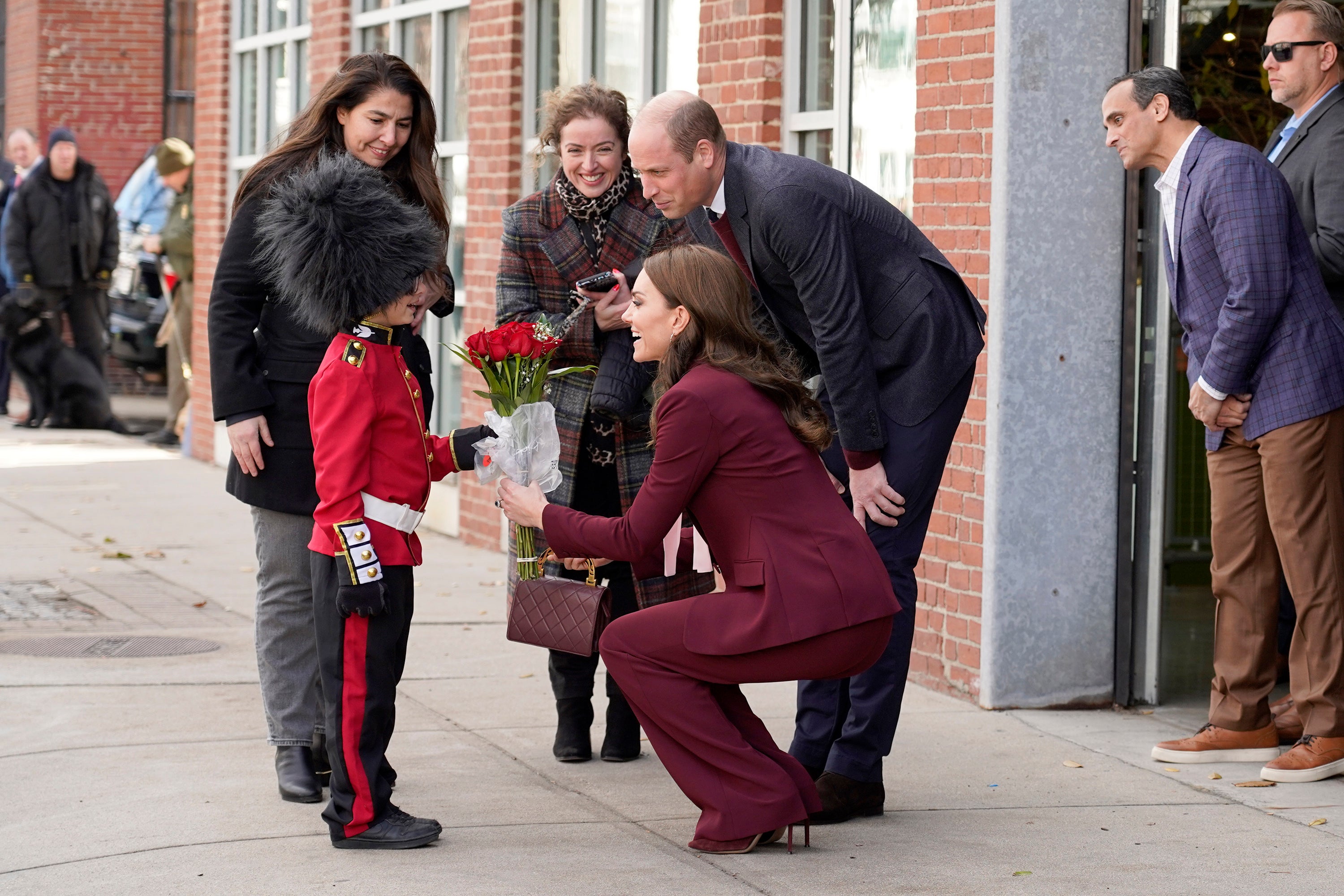 Henry Dynov-Teixeira, 8, of Somerville, presents flowers to Kate, Princess of Wales, as his parents Melissa, left, and Irene, look on following a visit to Greentown Labs