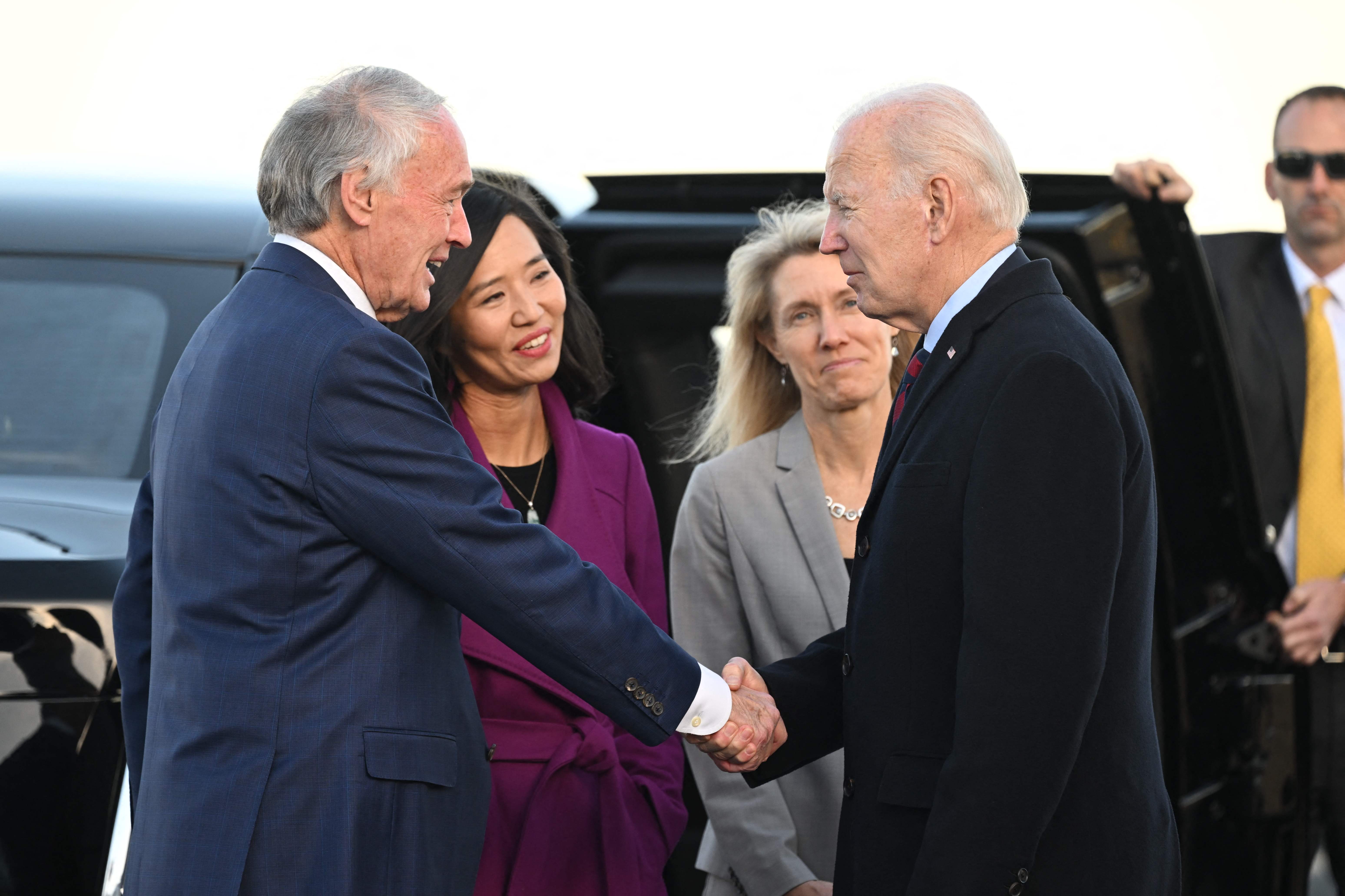 US President Joe Biden is greeted by US Senator Ed Markey and Boston Mayor Michelle Wu (2nd L) on arrival at Boston Logan International Airport on December 2, 2022, in Boston, Massachusetts