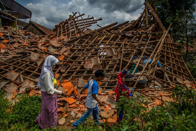 <p>Children of earthquake victims walk past a collapsed house at Cugenang village in Cianjur, West Java</p>