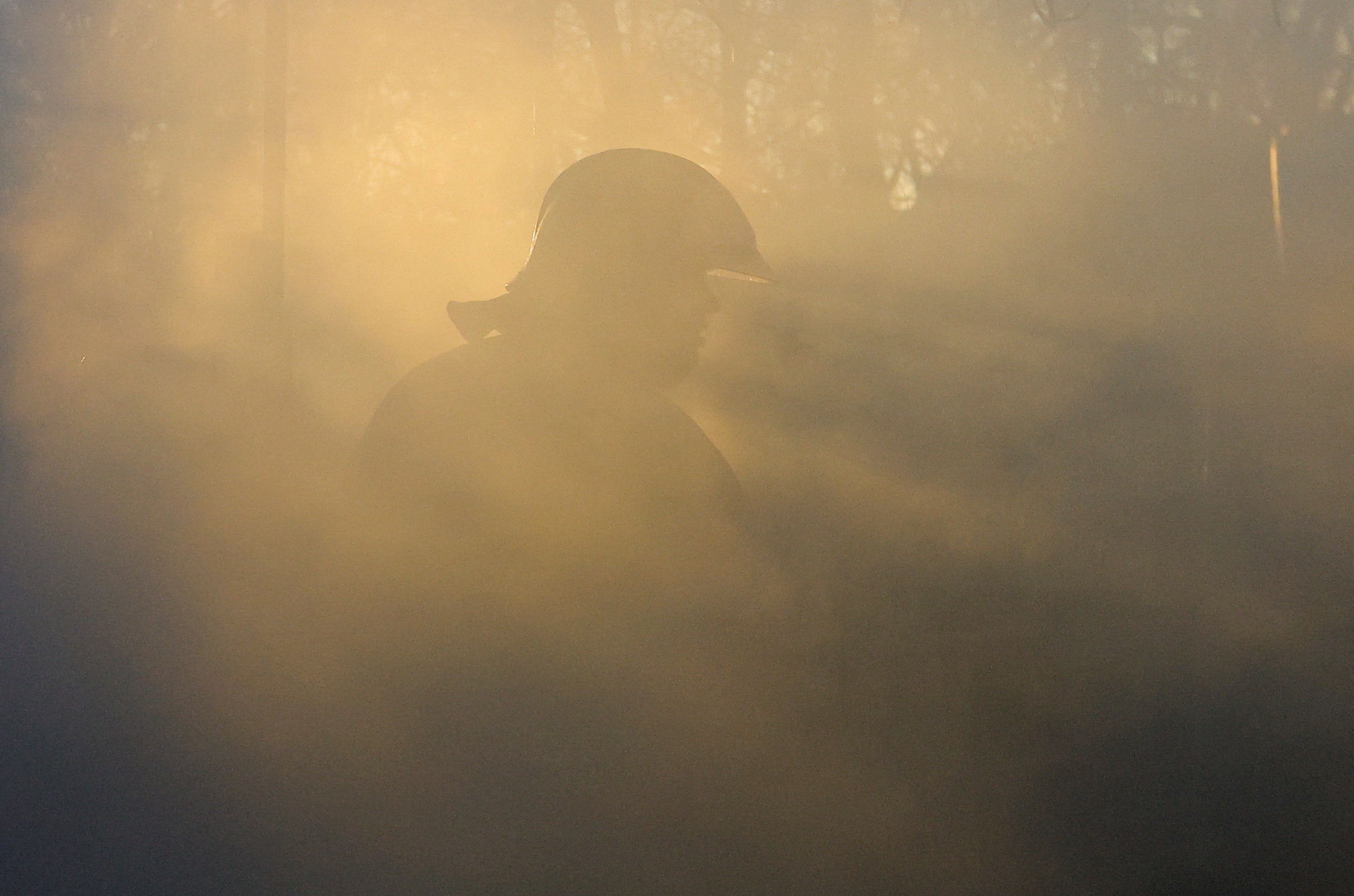 A firefighter walks amid smoke while working in an office building heavily damaged in shelling in Donetsk