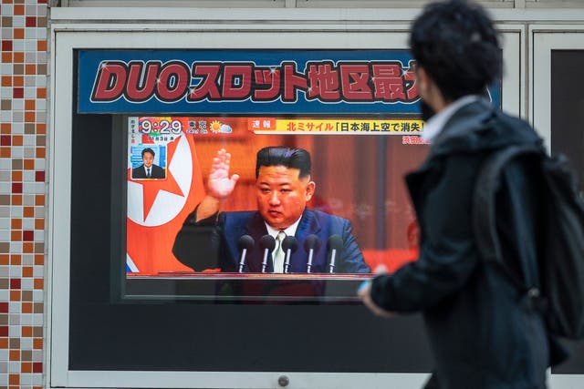 <p>File: A man walks past a television screen showing a news report with images of the North Korean leader Kim Jong-un along a pedestrian walkway in Tokyo</p>
