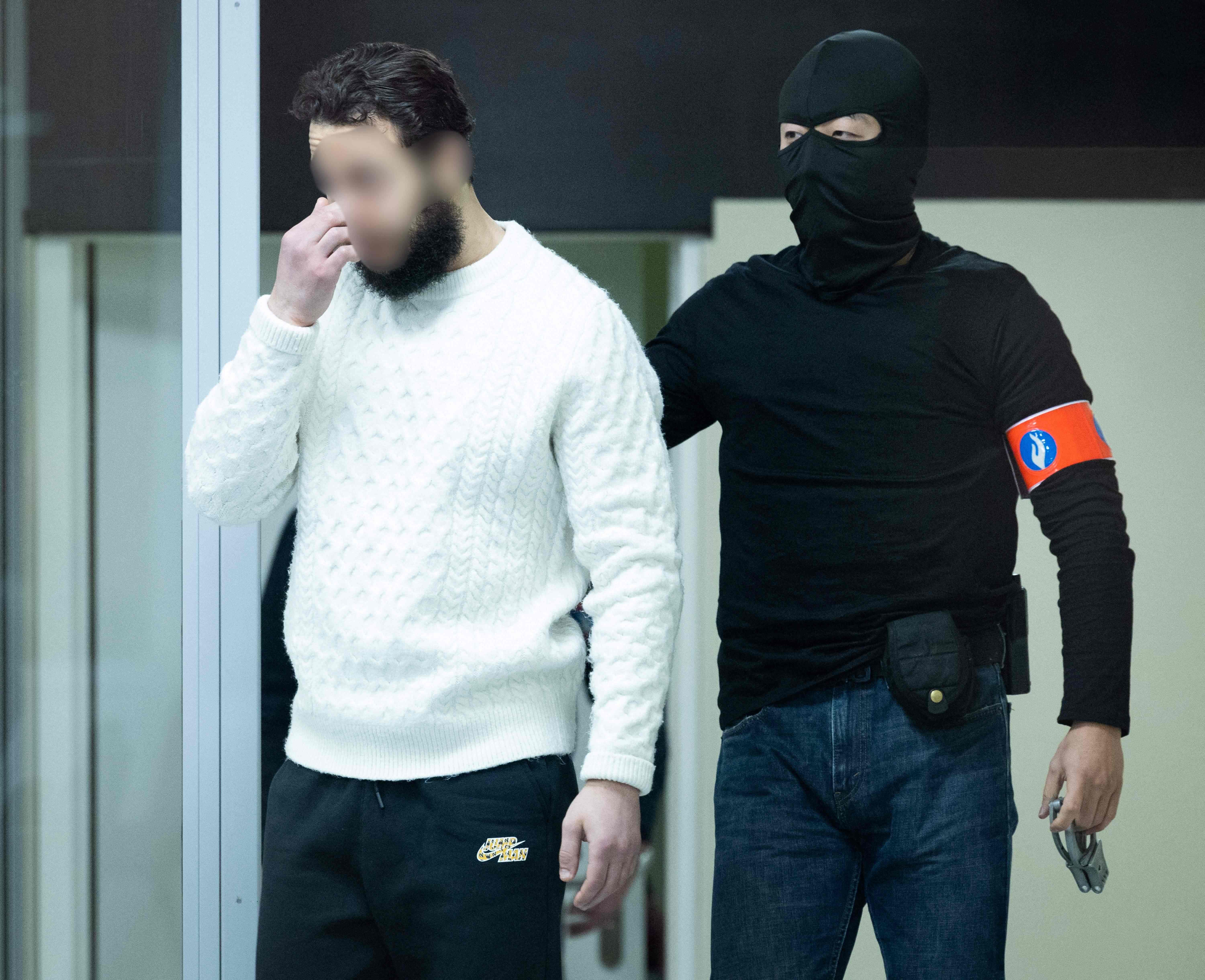Defendant Salah Abdeslam arrives under police escort for the trial of alleged jihadists