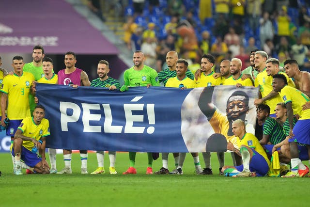 Brazil’s players hold up a Pele banner on the pitch after their win over South Korea (Martin Rickett/PA).