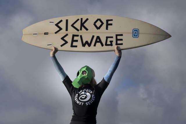 <p>A representative from Surfers against Sewage protests against sewage discharges at an overflow pipe on Long Rock Beach in Penzance, Cornwall, to coincide with the publication of The 2022 Water Quality report.</p>