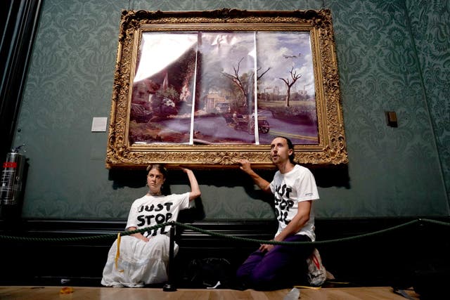 Hannah Hunt and Eden Lazarus glued themselves to the painting (Kirsty O’Connor/PA)