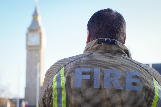 <p>A firefighter in Parliament Square, central London, ahead of a rally to mark the start of a ballot for strikes in a dispute over pay</p>
