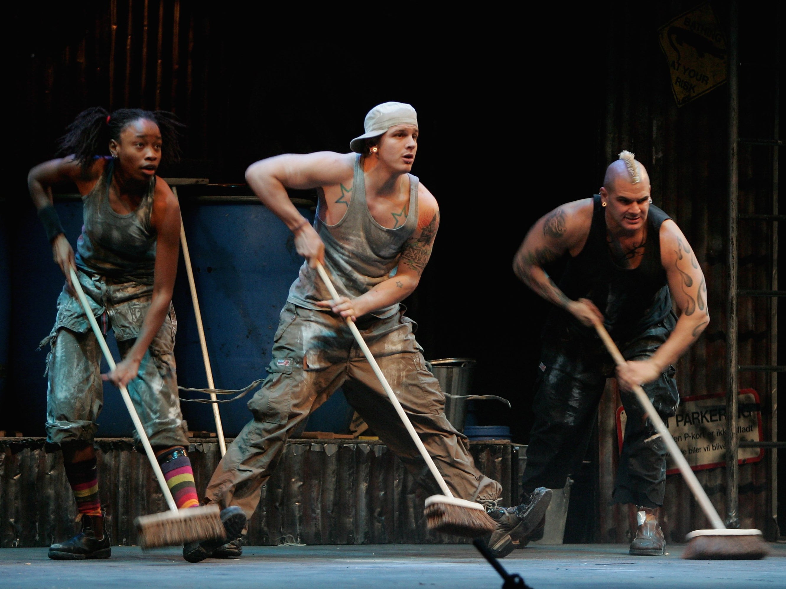 Performers using brooms as percussive instruments during a performance of ‘Stomp’ in Berlin, Germany