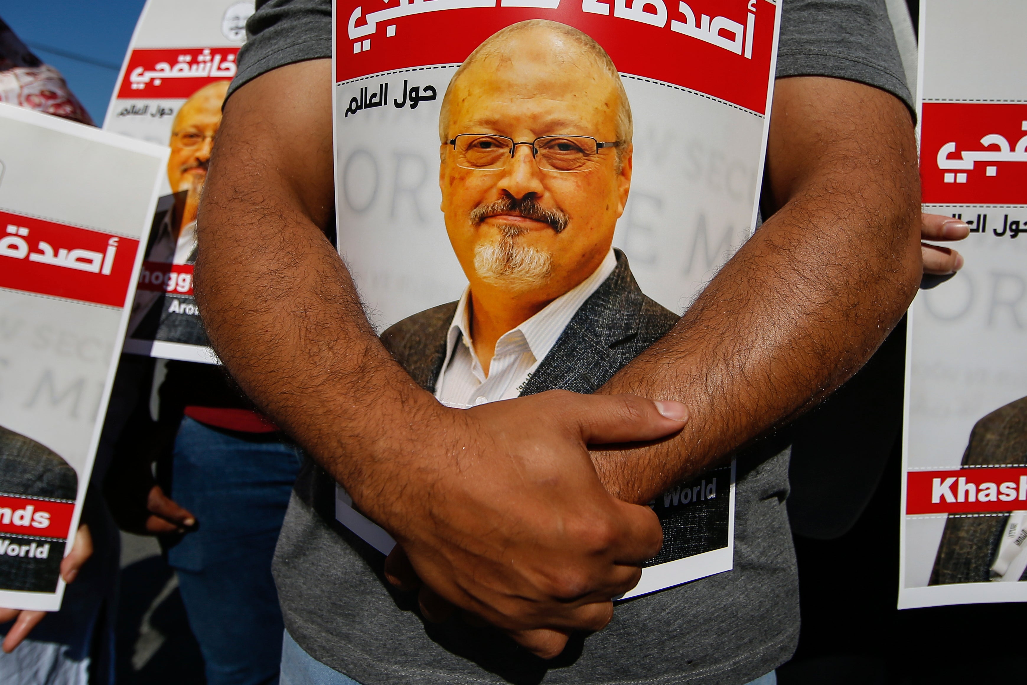 People hold posters of slain Saudi journalist Jamal Khashoggi