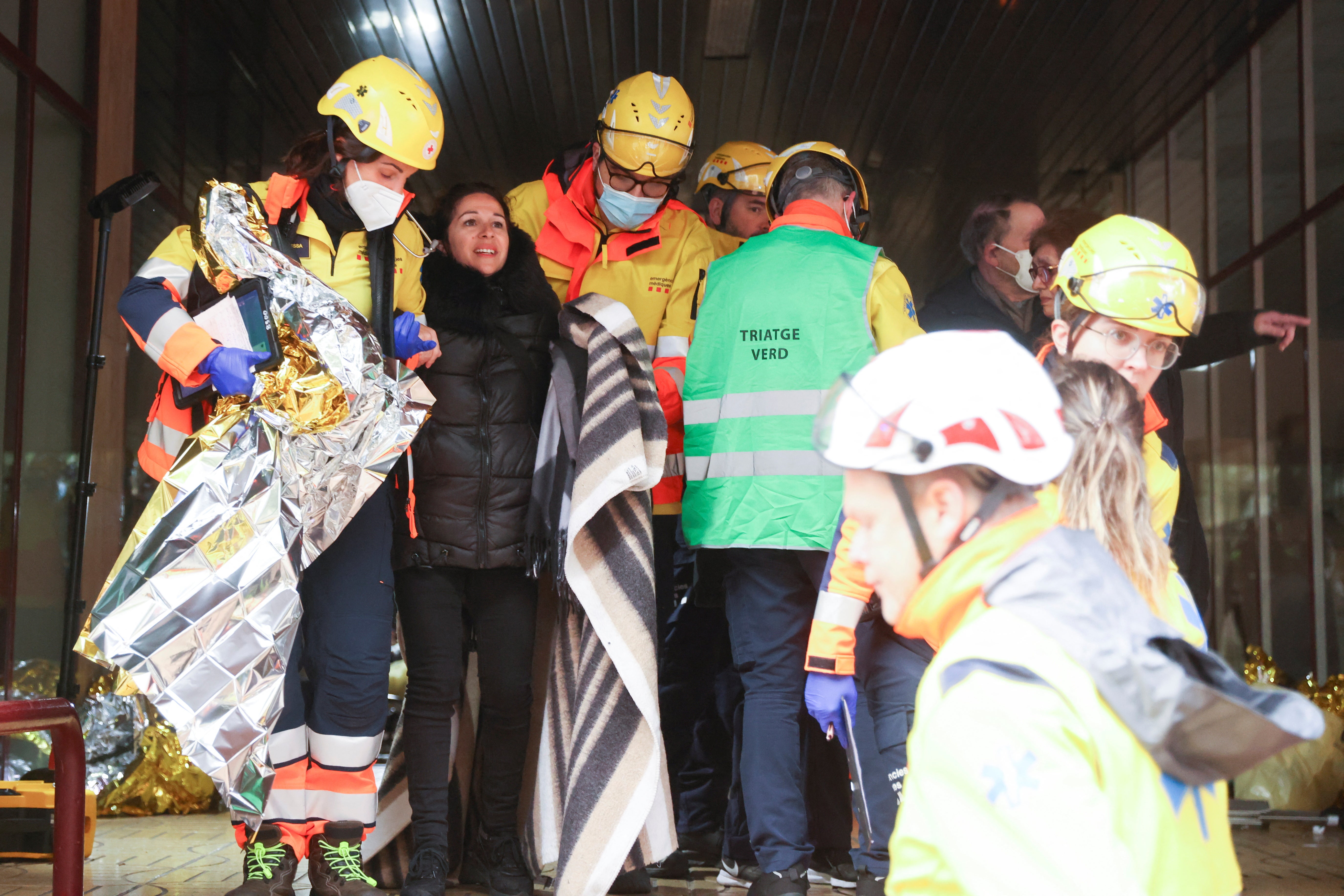 A wounded person is helped by medical emergency after two trains collided in Spain's northeastern Catalonia region