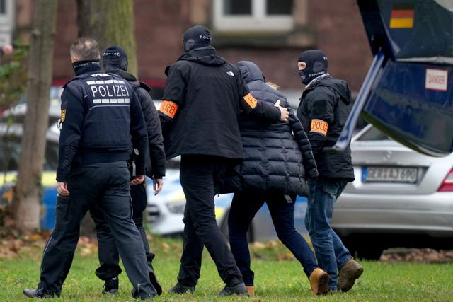 <p>A suspect, second right, is escorted from a police helicopter by officers for questioning at the federal prosecutor’s office in Karlsruhe</p>