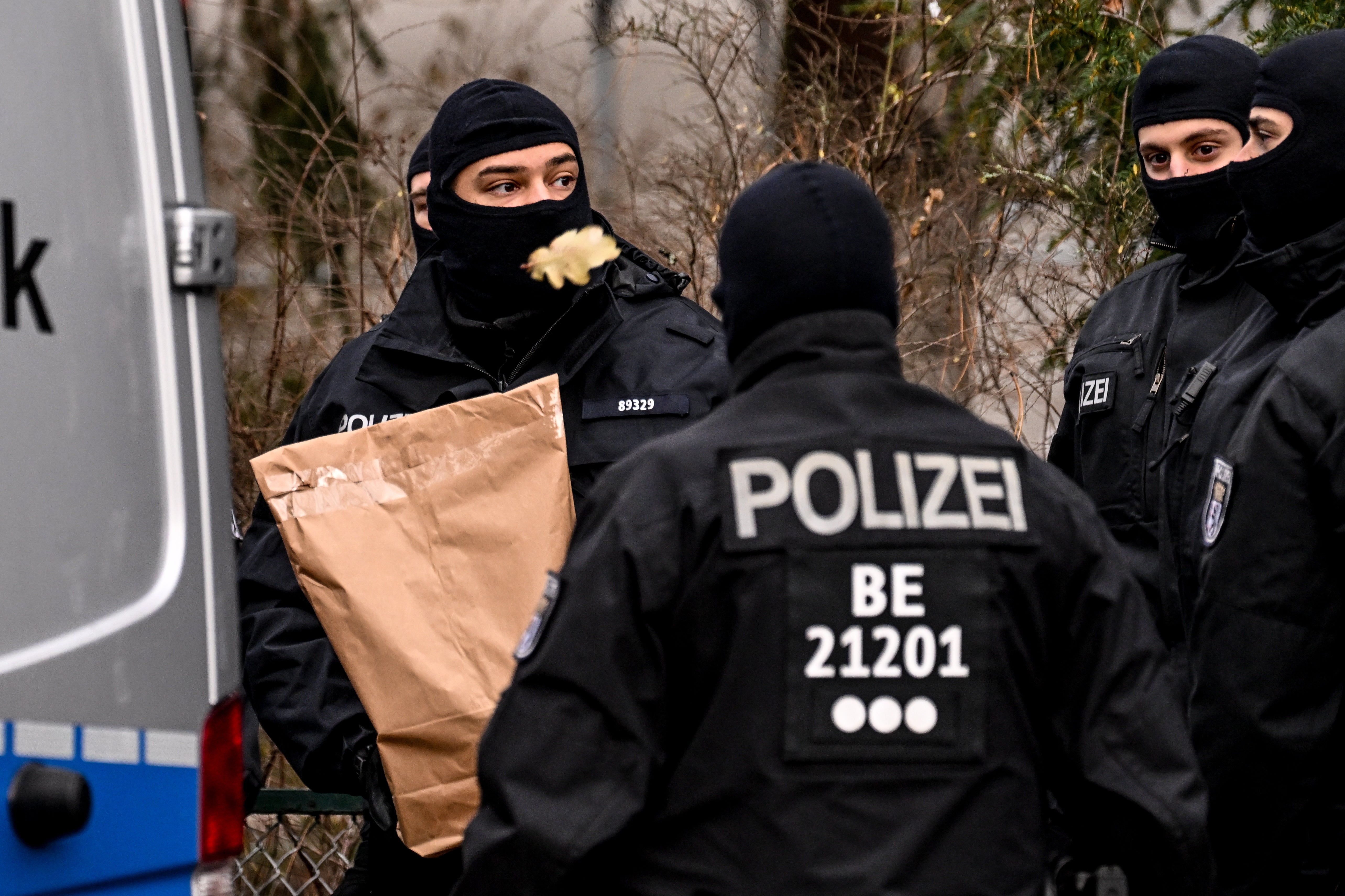 Police officers work during a raid in Berlin