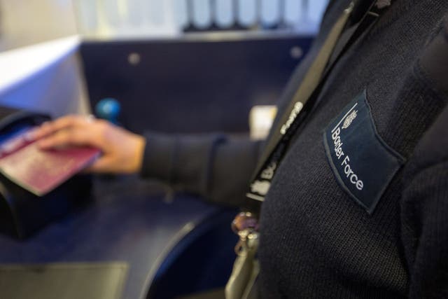 <p>A Border Force officer checks passports (Steve Parsons/PA)</p>