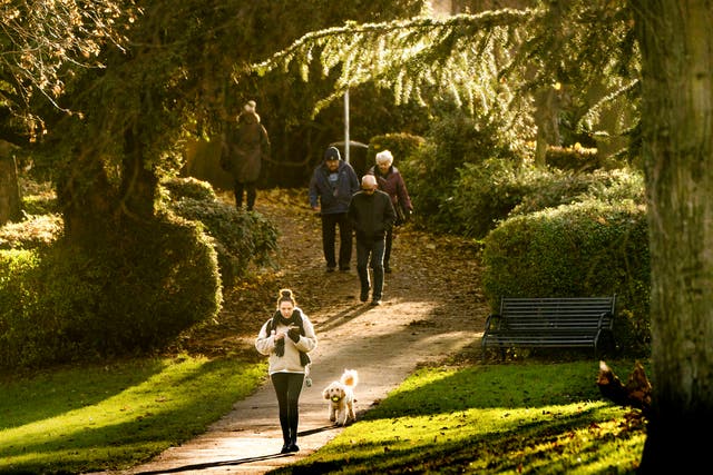 Los caminantes se bañan en la luz del sol en Springhead Park en Rothwell,