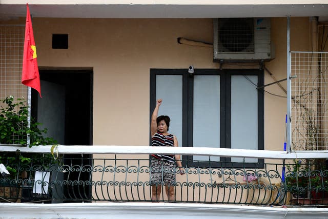 <p>This picture taken on 5 September 2021 shows a woman exercising on the balcony of her home in Hanoi, Vietnam</p>